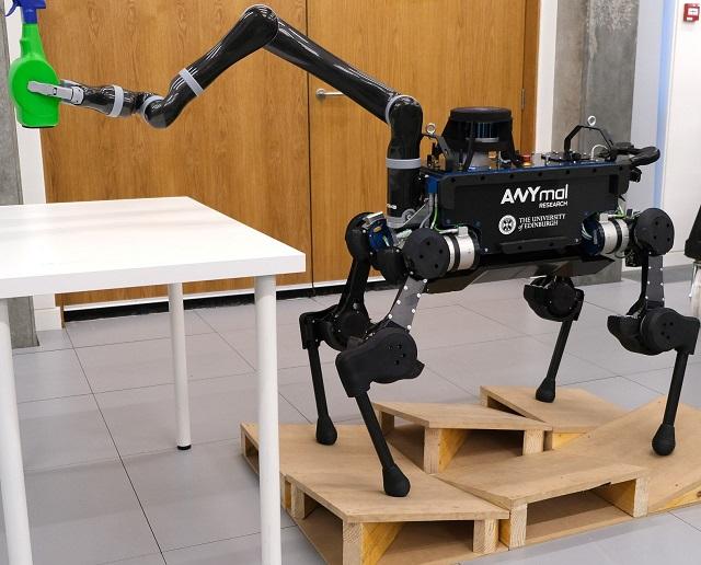 Photo of ANYmal Bull robot holding a plastic bottle with robotic arm
