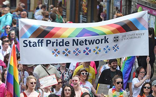 Photo of University students and staff marching at Edinburgh Pride holding a Staff Pride Network banner